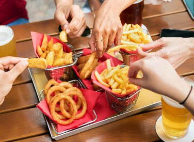 people eating french fries and onion rings appetizer sides at a restaurant