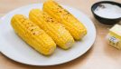 cooked corn with salt and butter on a plate