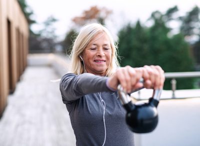 senior woman doing kettlebell exercises, strength workout for a younger looking body