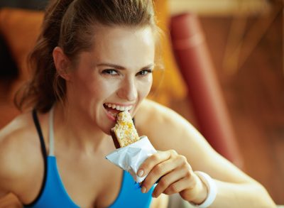 fitness woman eating a granola bar